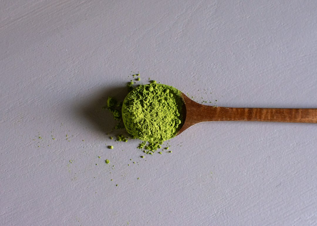 Polvo de matcha verde sobre una cuchara de madera